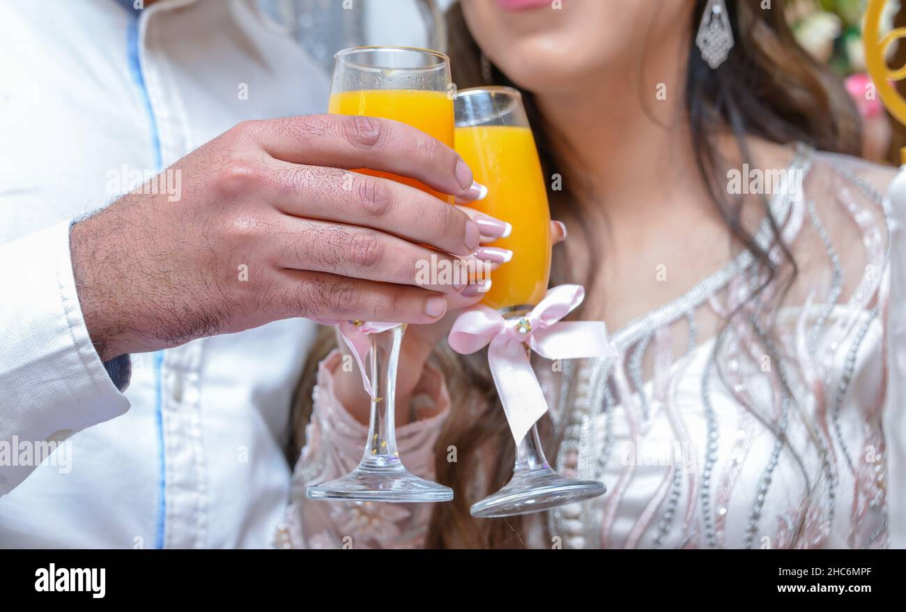 The bride and groom are holding glasses with juice in their hands Stock Photo