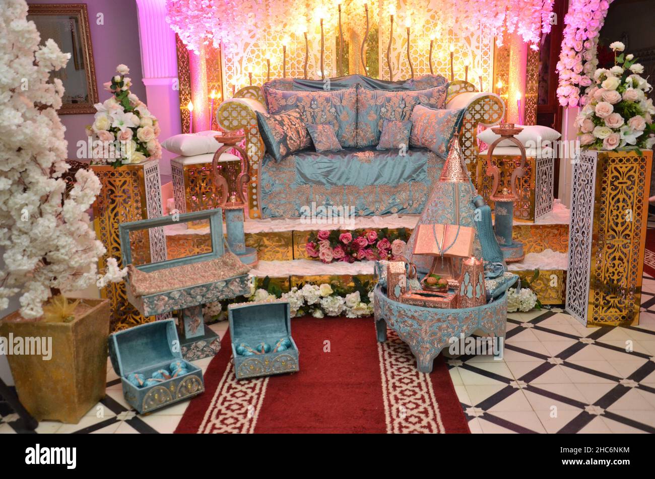 An elegantly staged traditional MOROCCAN style wedding with large sofa for the wedding couple to sit and receive blessings from the guests, surrounded Stock Photo