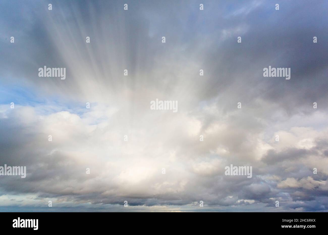 dramatic sky with rays of sunlight breaking through from behind the clouds Stock Photo