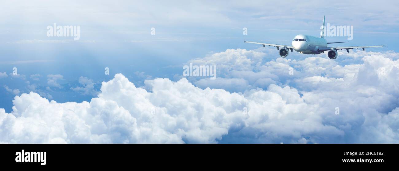 Jet plane in a blue cloudy sky. Panoramic composition in high resolution. Stock Photo