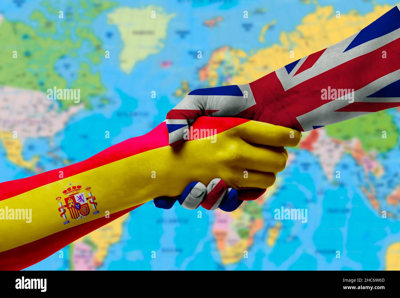 Flags Spain and the United Kingdom countries, handshake cooperation, partnership and friendship or sports competition.With background of world map Stock Photo