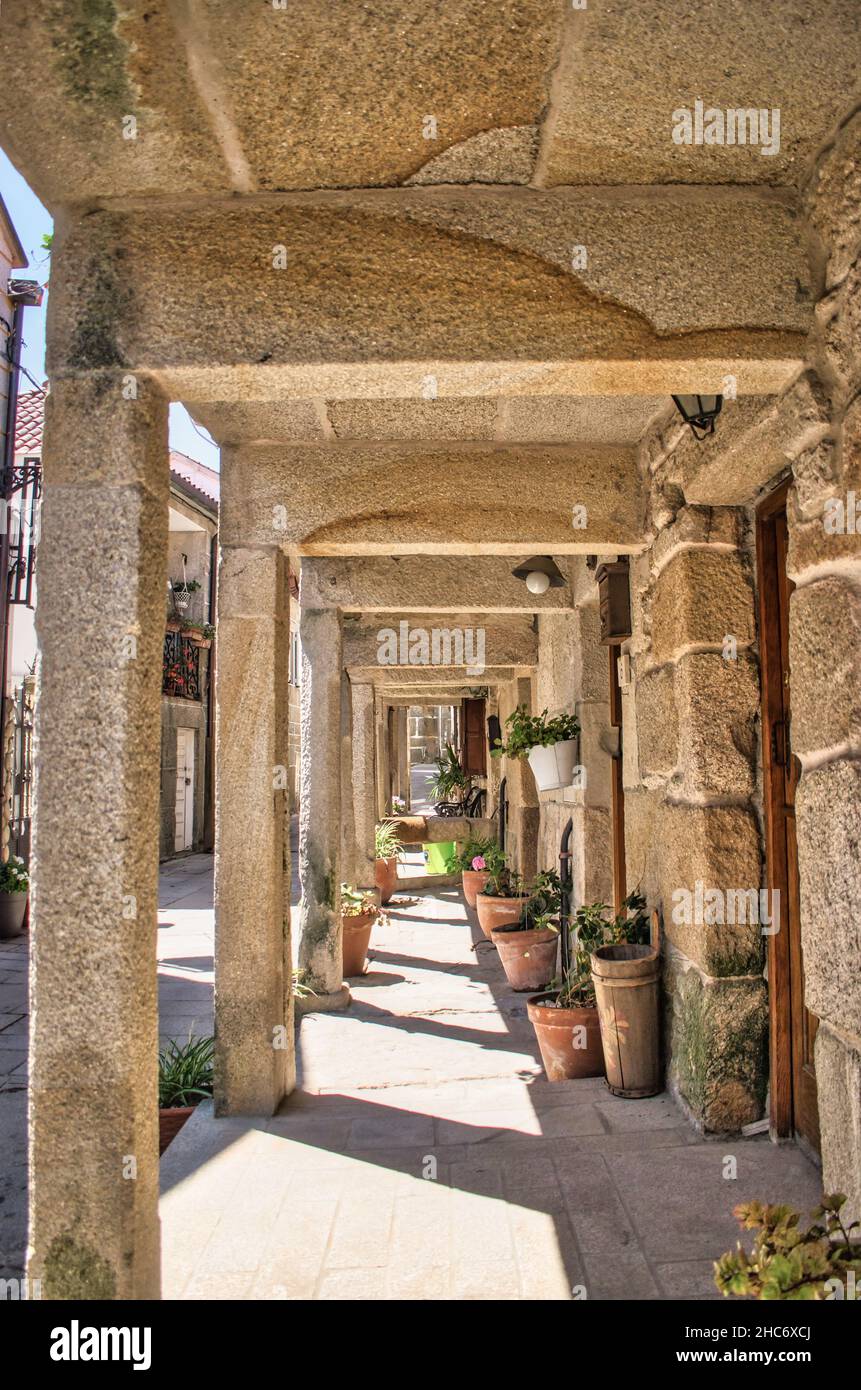 Soportal y macetas bajo tradicionales casas de piedra en el pueblo medieval de Combarro, España Stock Photo