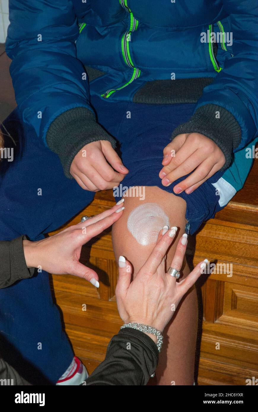 Woman spreading ointment on boy's knee. Stock Photo