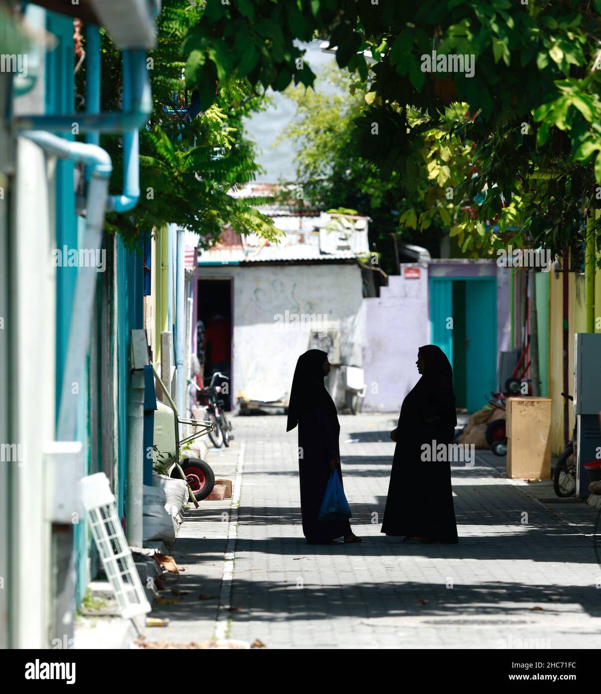 Two Maldivian women talking on one of the streets of Villingili Island near Male Stock Photo
