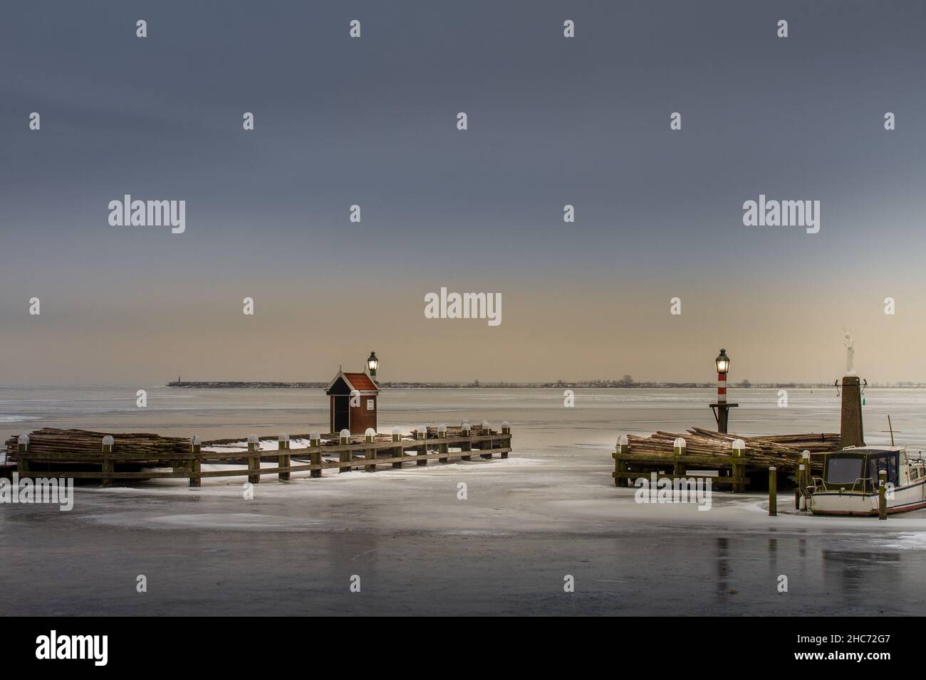 Landscape scenery of the frozen harbor of Volendam at sunset time Stock Photo