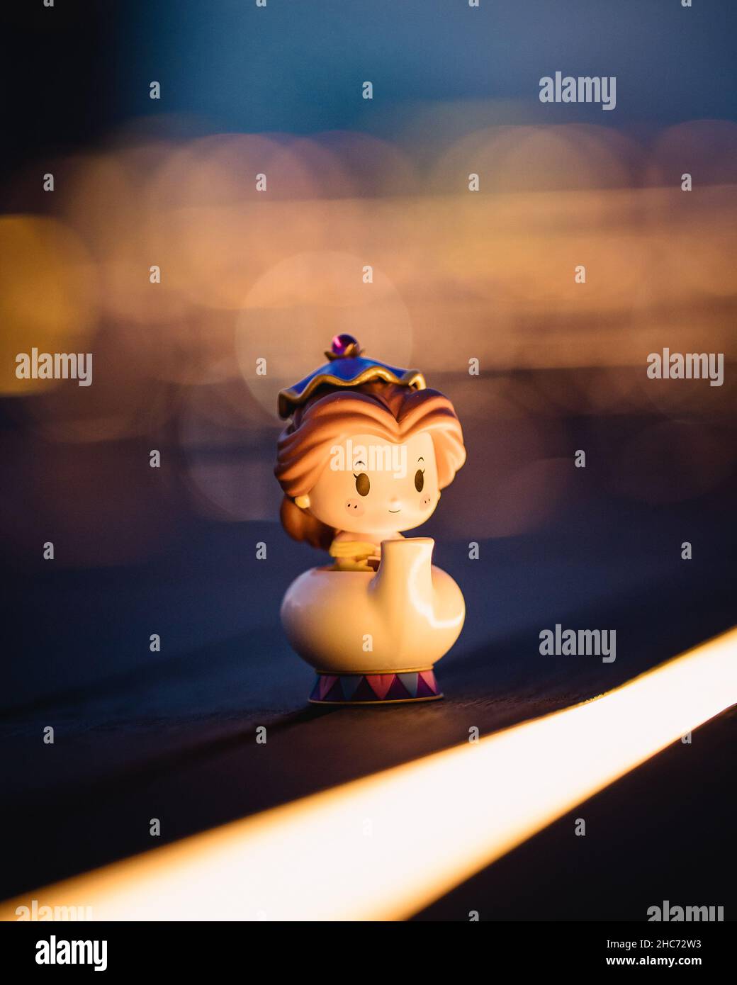 Vertical shot of a small plastic toy of Belle from Beauty and the Beast in a teapo Stock Photo