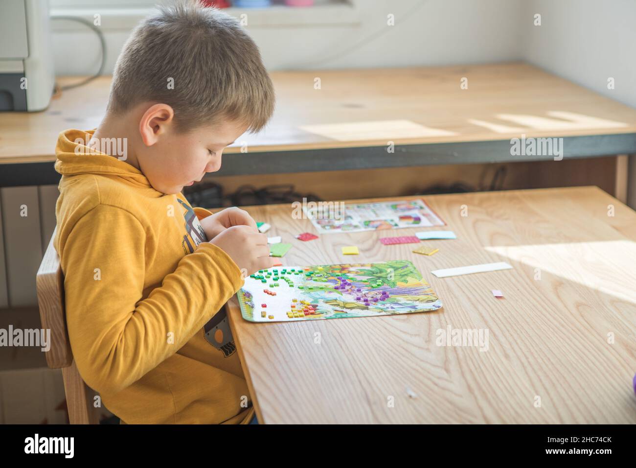Little boy being creative making homemade do it yourself dinosaur ...