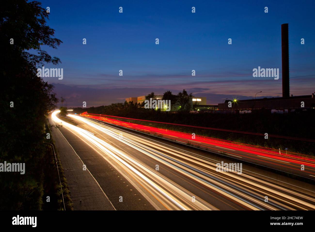 Night highway with yellow and red lights with dark blue sky on the background Stock Photo