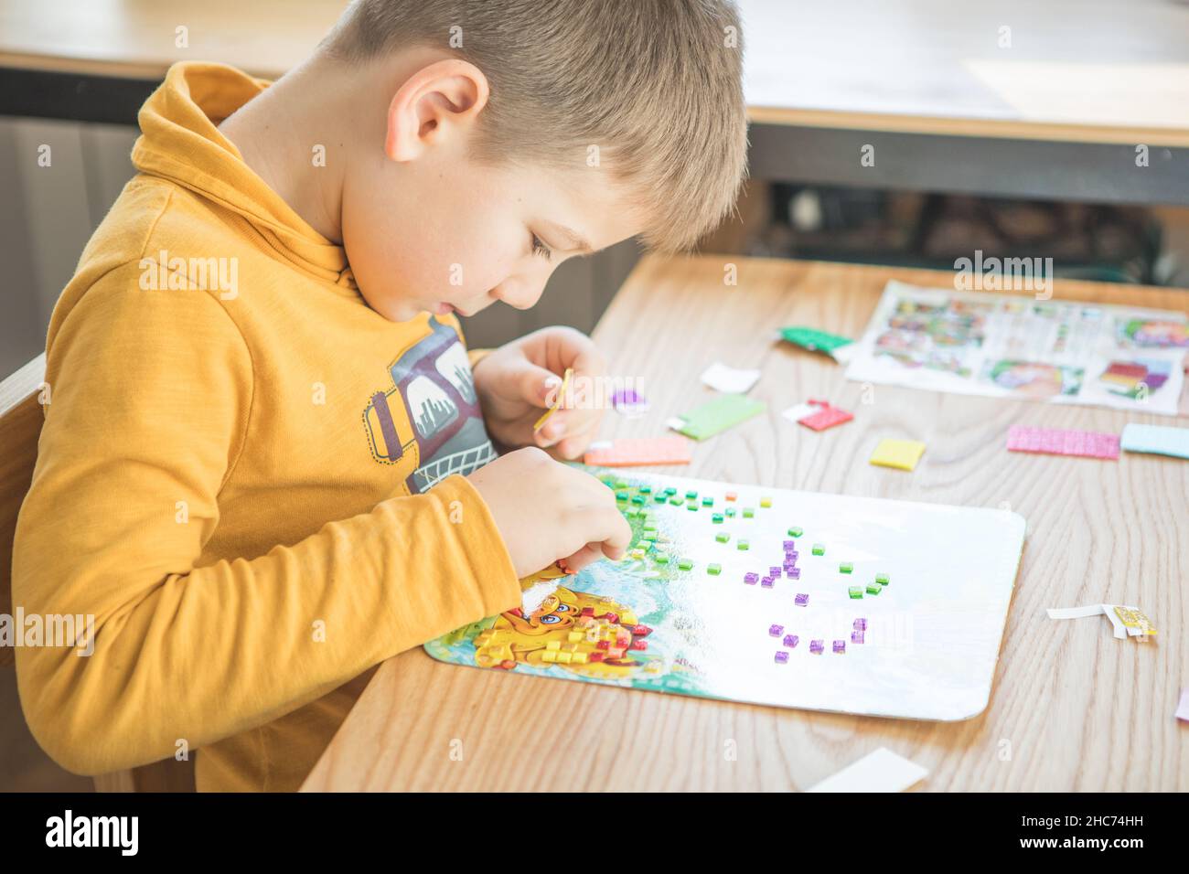 Little boy being creative making homemade do it yourself dinosaur ...