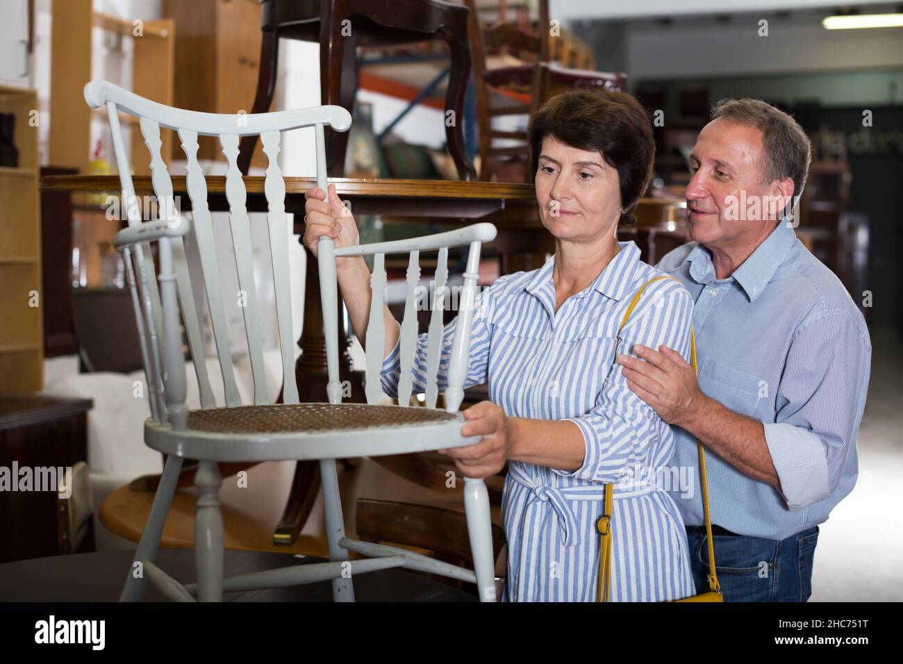 Mature man with his wife are buying armchair Stock Photo Alamy