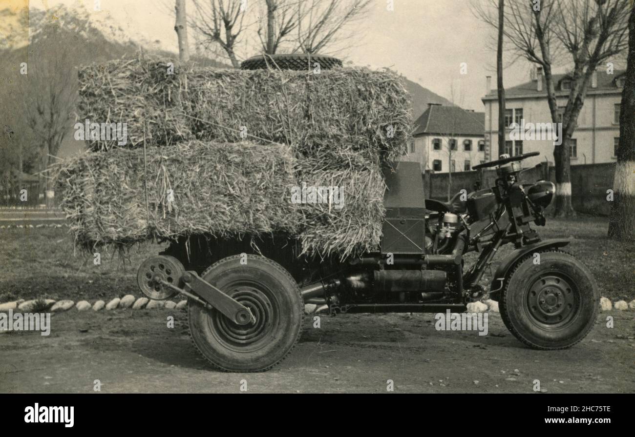 Small transporting vehicle carrying hay bales, Italy 1950s Stock Photo