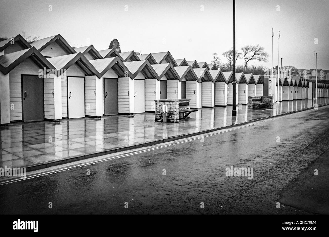 A Black and white treatment of Swanage seaside huts reflected on a wet day looking like an old postcard Stock Photo