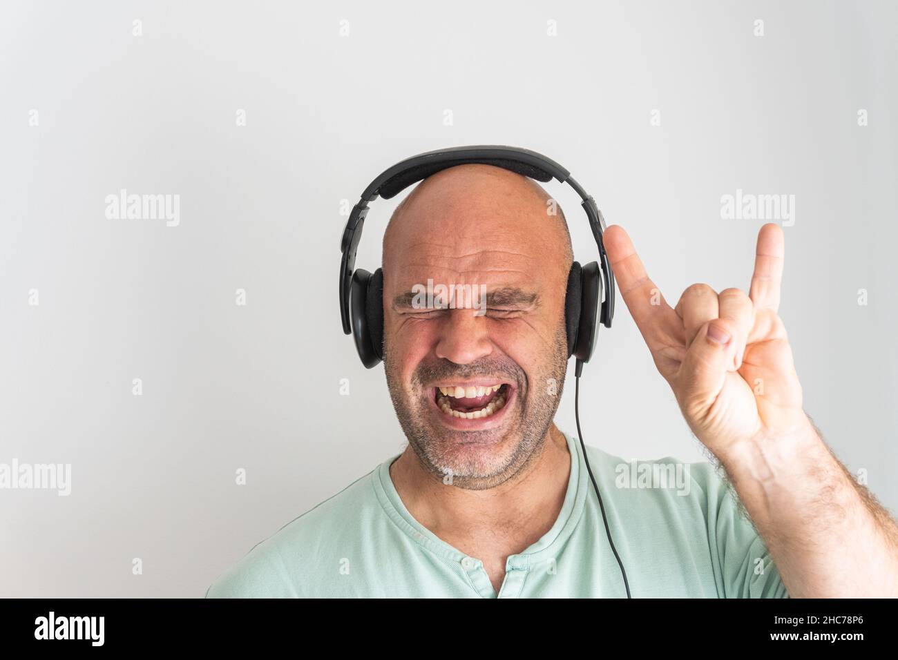 Close-up shot of a face of a bald and bearded Caucasian man, wearing headphones Stock Photo