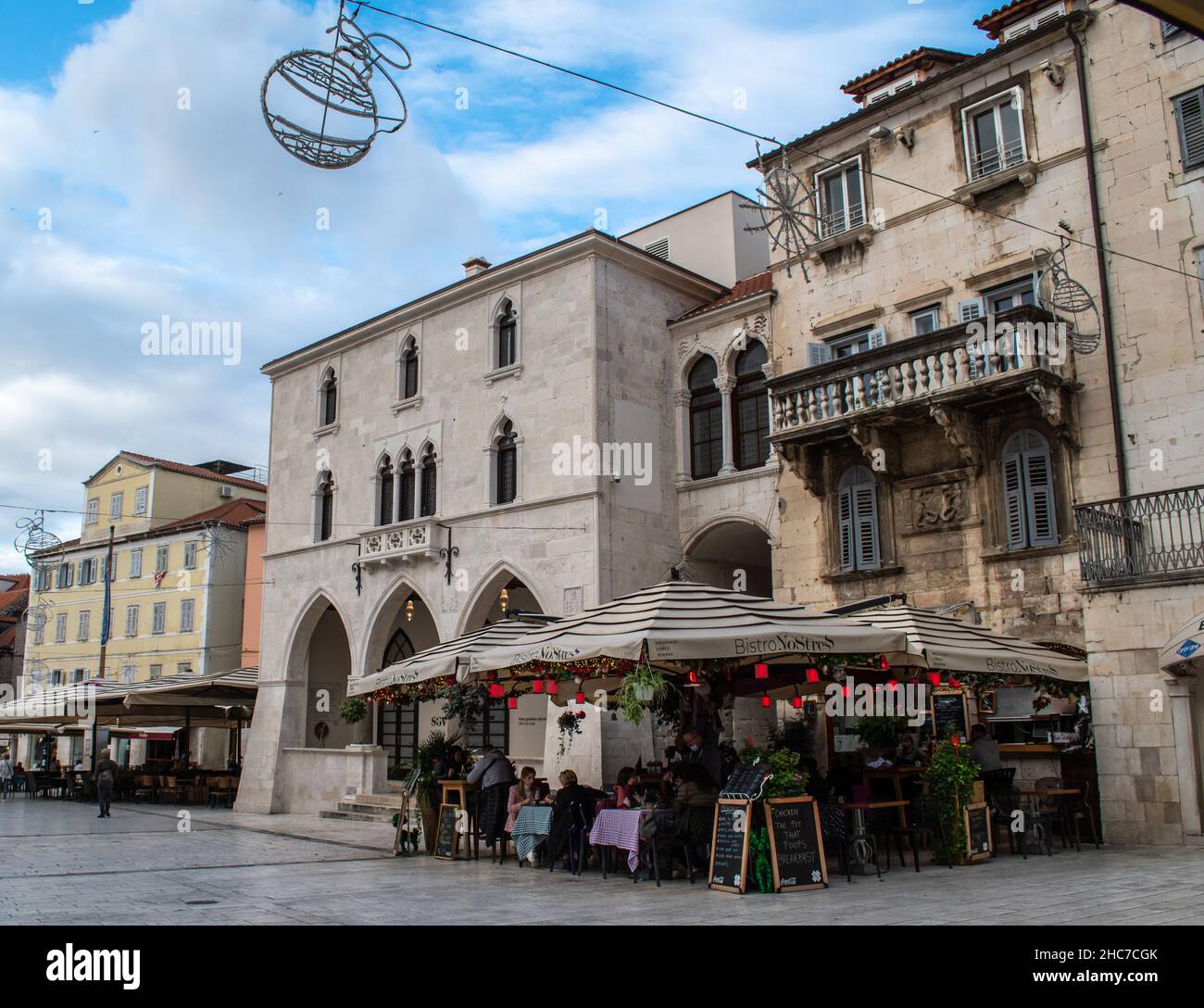 Walkway lined with restaurants and cafes, popular gathering place for locals and tourists in Split, Croatia. Awnings cover outdoor tables and chairs Stock Photo