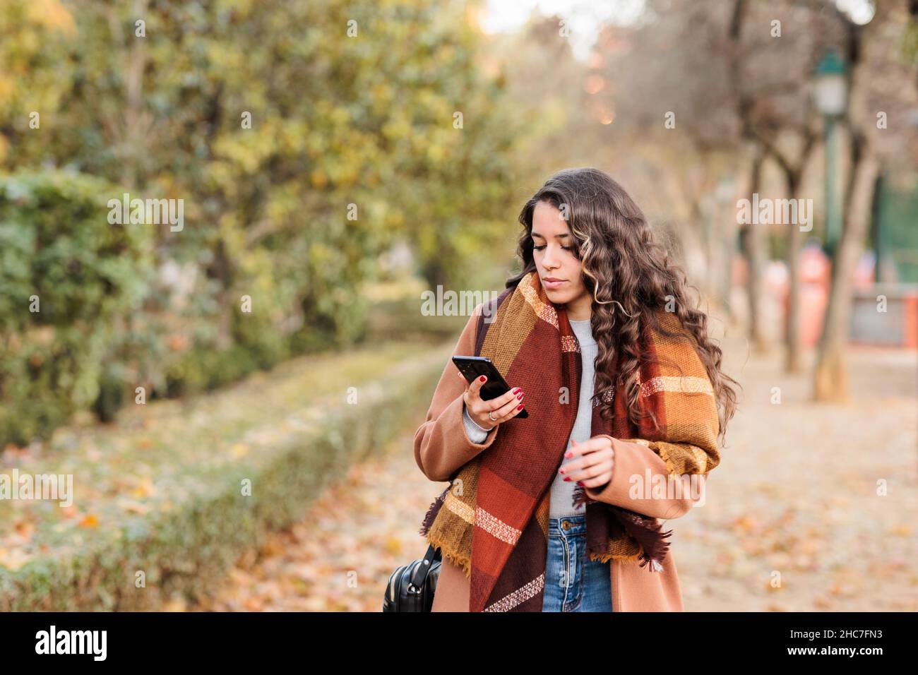 Spanish business woman communicating with smartphone in Castilla la mancha, Toledo. Fall colors Stock Photo