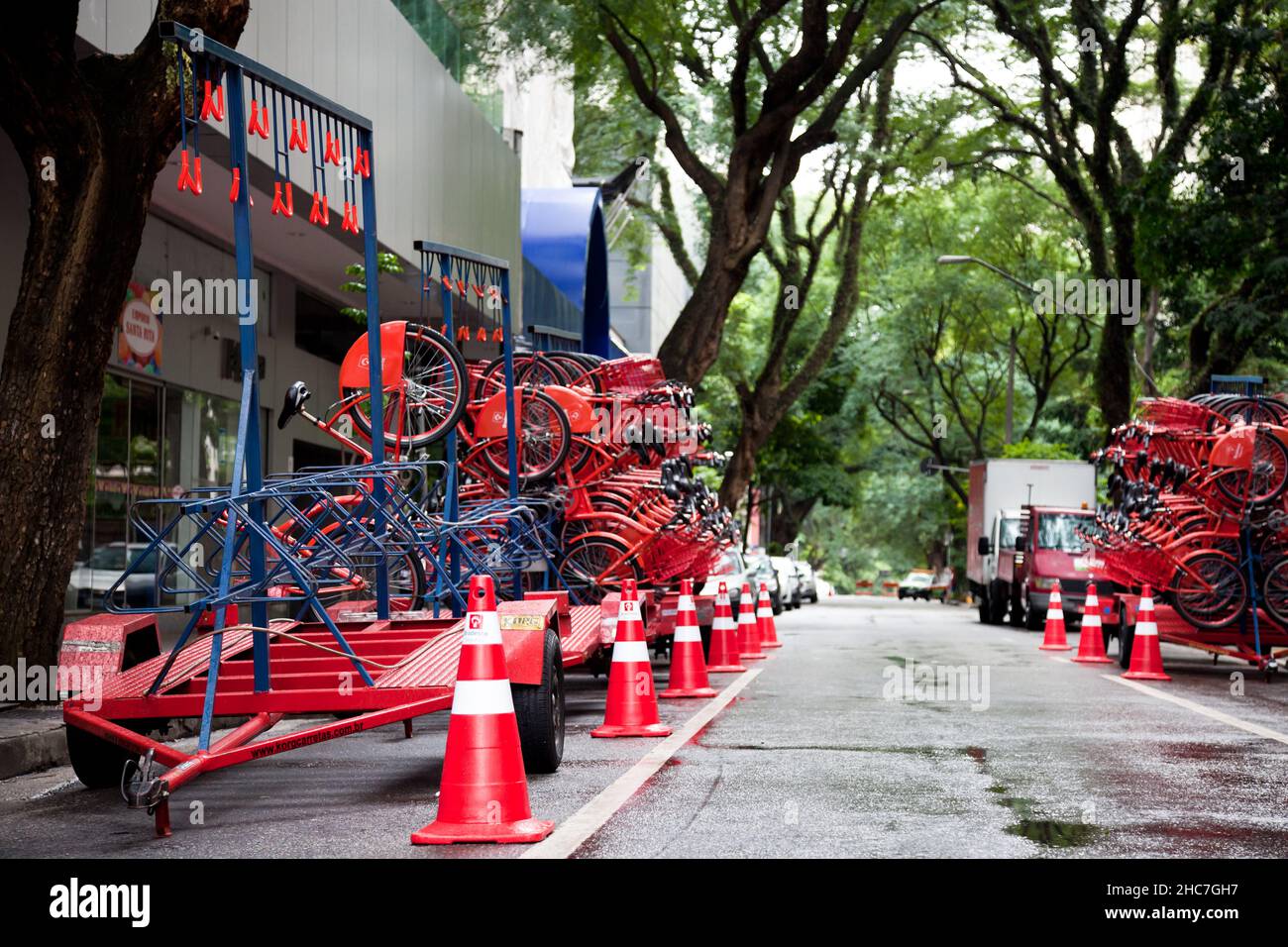 Red bikes on street trailers placed next to a sidewalk in the street of Sao Paolo, Brazil Stock Photo