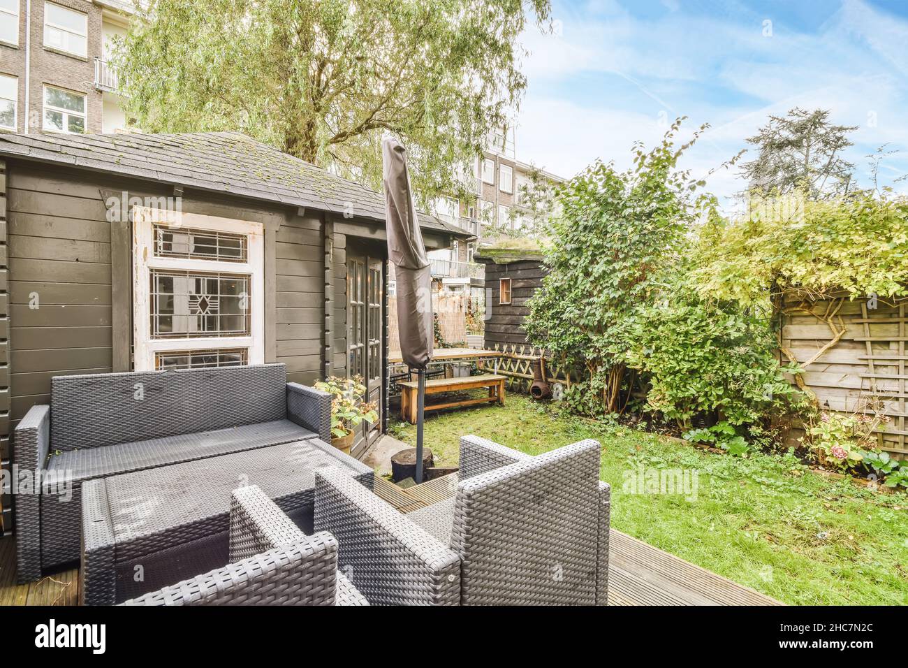 Cozy courtyard of the house with a fresh lawn and a black adjoining ...