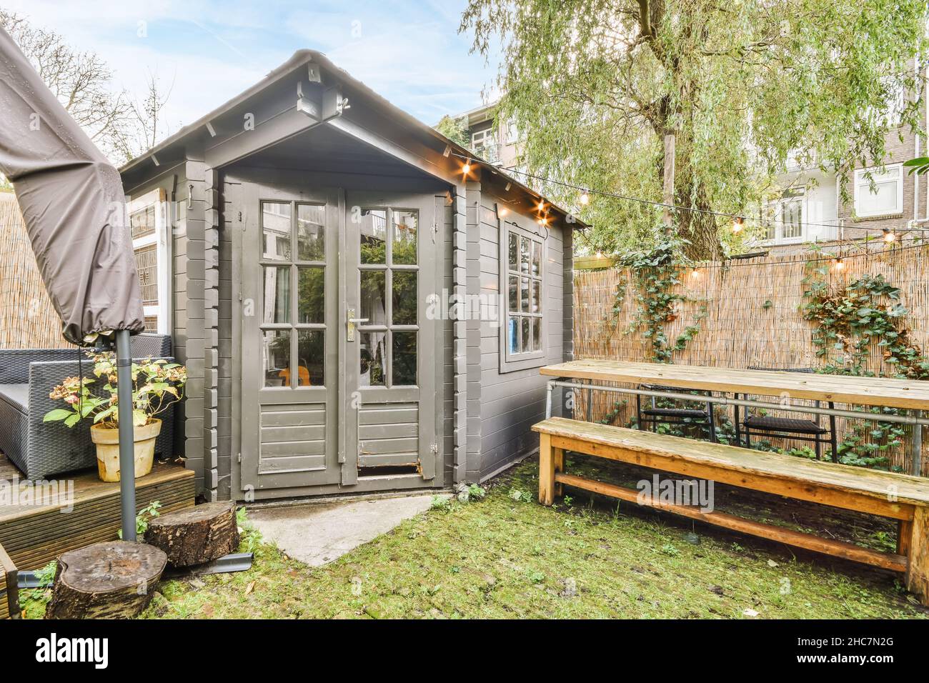 Cozy courtyard of the house with a fresh lawn and a black adjoining ...
