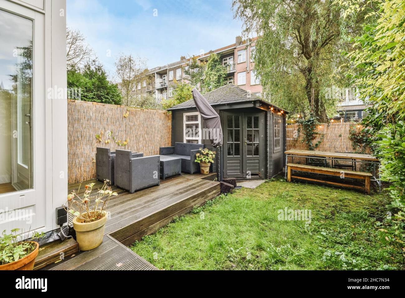Cozy courtyard of the house with a fresh lawn and a black adjoining ...