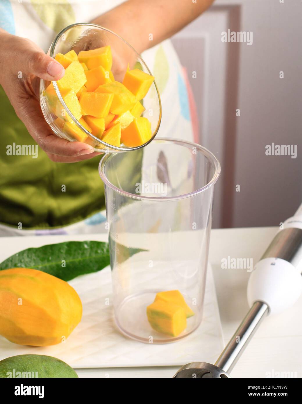 Asian Female Making Mango Juice with Hand Blender. Step by Step, Put