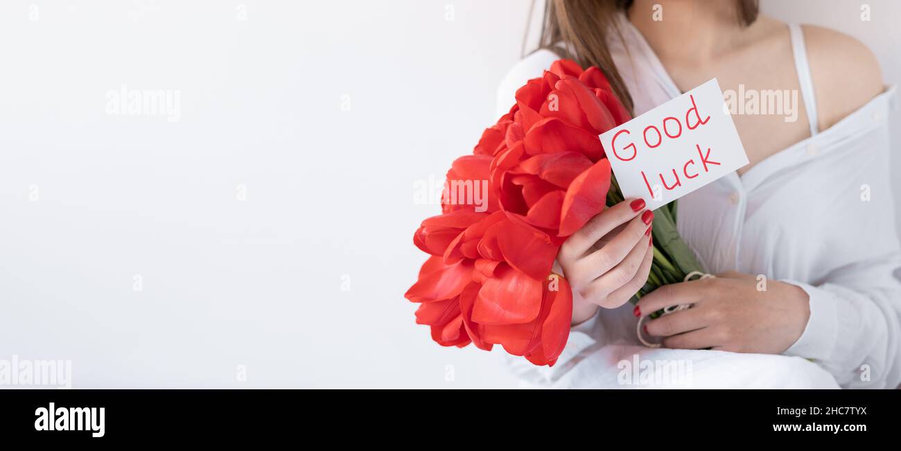 Bouquet of red tulips and wish of good luck on a white background. The