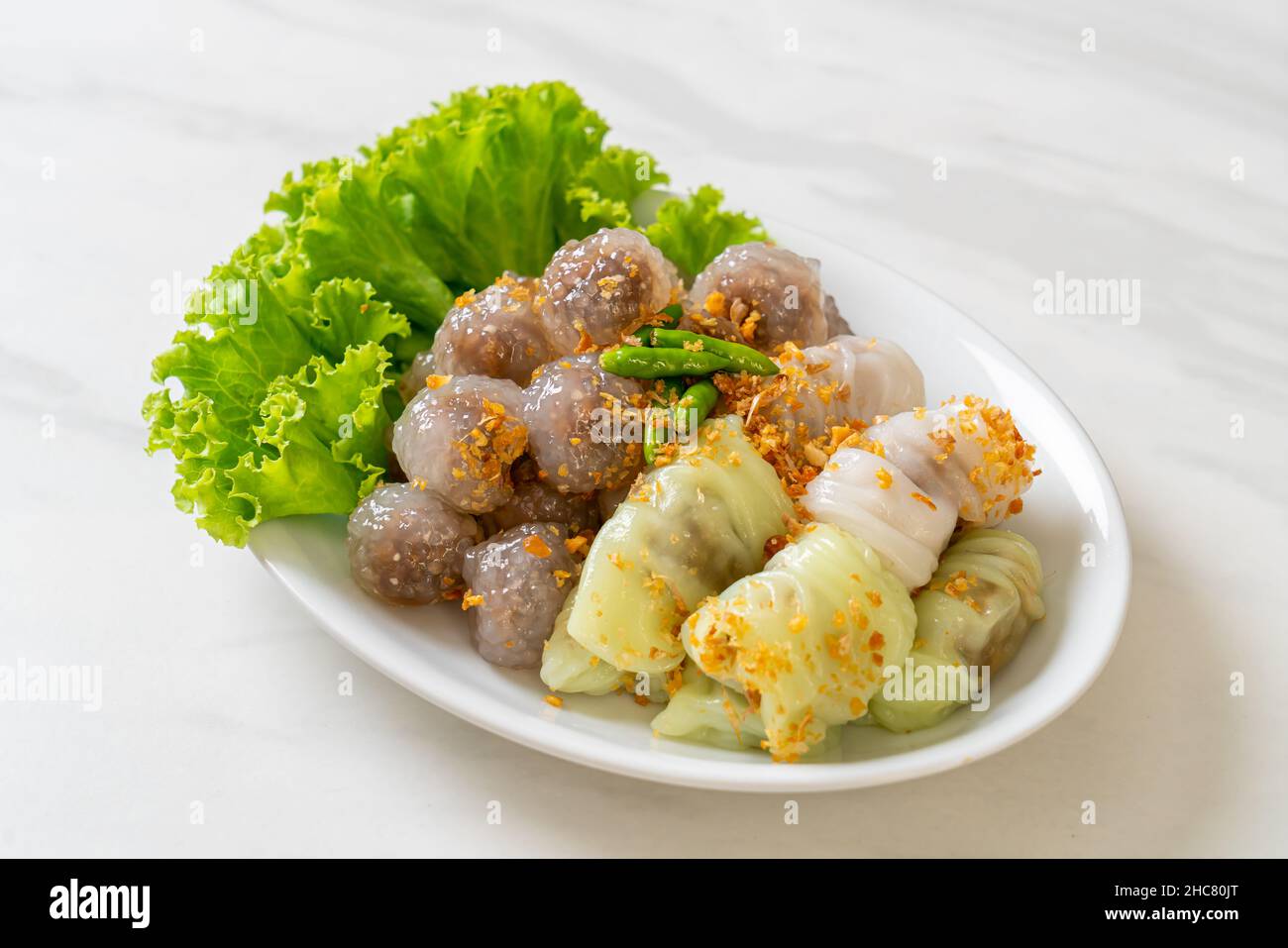 The transparent balls are called Saku Sai Moo or Steamed Tapioca Dumplings Ball with Pork Filling and ( Kow Griep Pag Mor)Pork Steamed Rice Parcels or Stock Photo