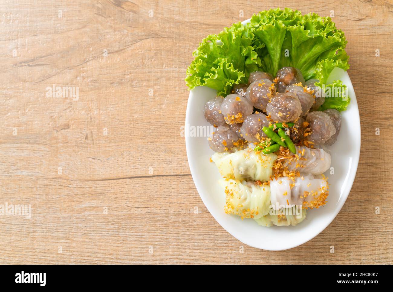 The transparent balls are called Saku Sai Moo or Steamed Tapioca Dumplings Ball with Pork Filling and ( Kow Griep Pag Mor)Pork Steamed Rice Parcels or Stock Photo