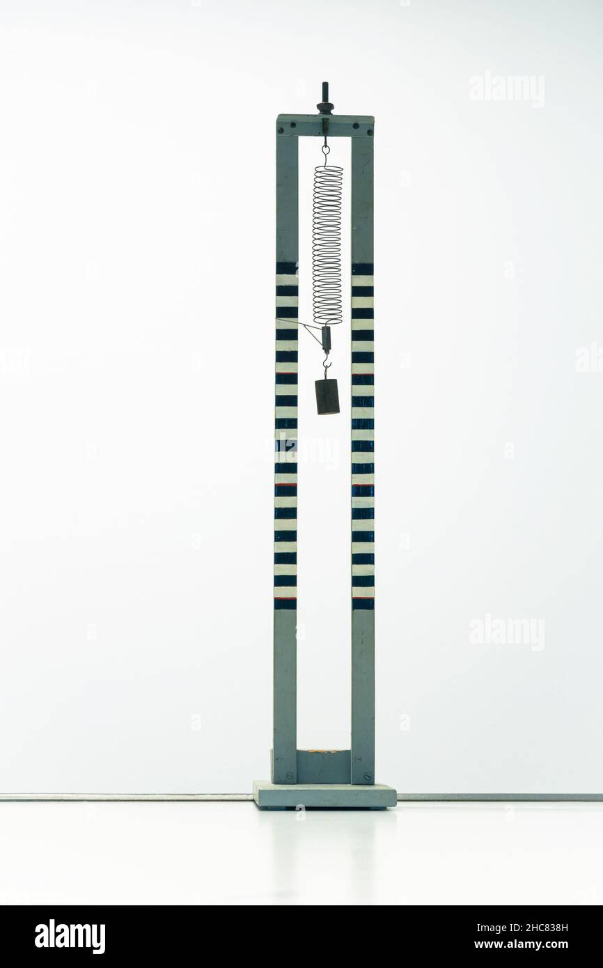 Scientific installation with a weight hanging from a coil spring for
