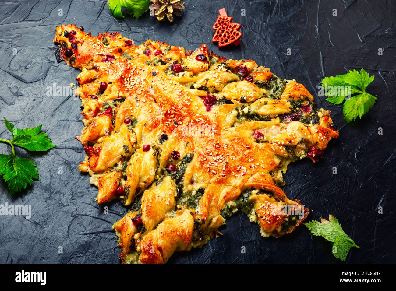 Vegetarian spinach pie for Christmas. Christmas cake and Christmas tree decorations. Stock Photo
