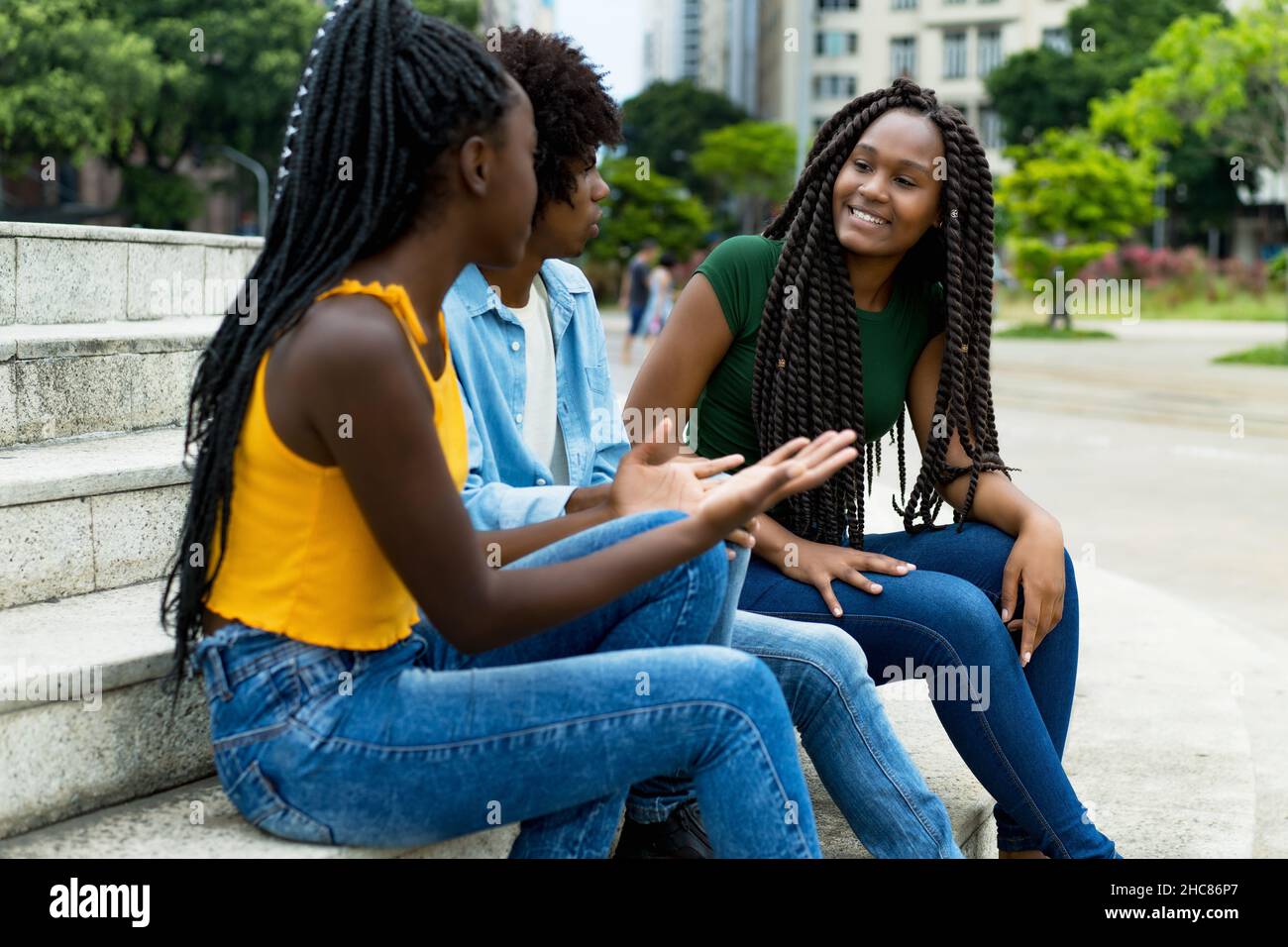 Group of chilling african american male and female young adults outdoor ...
