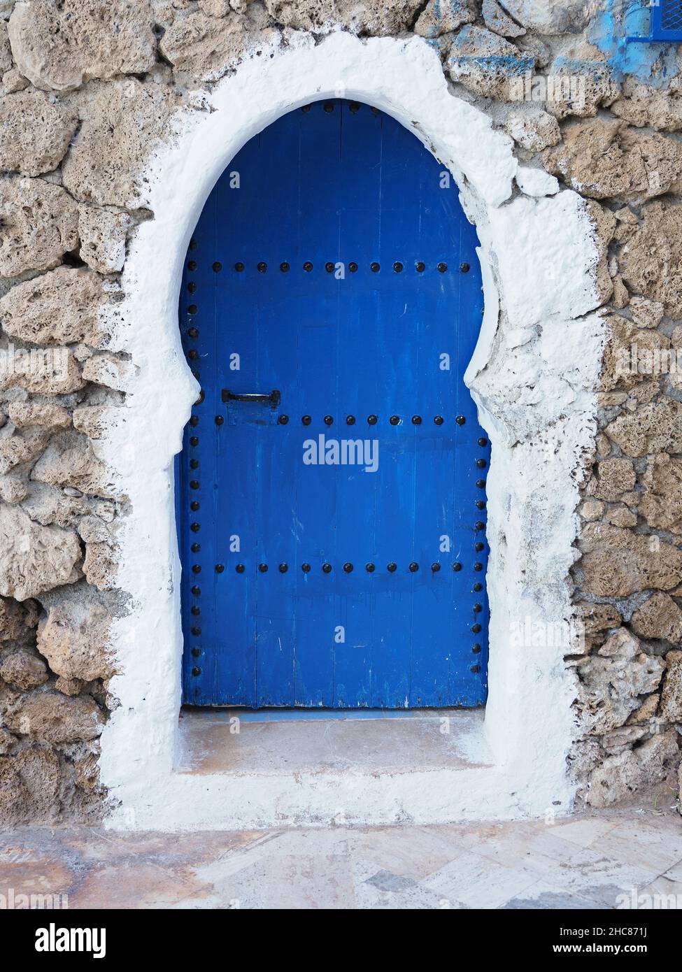 Islamic blue door in african Chefchaouen town in Morocco in 2019 warm sunny spring day on April - vertical Stock Photo