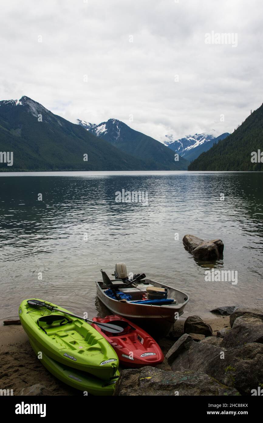 Vertical shot of Chilliwack lake with boats surrounded by snow-capped mountains in Canada Stock Photo