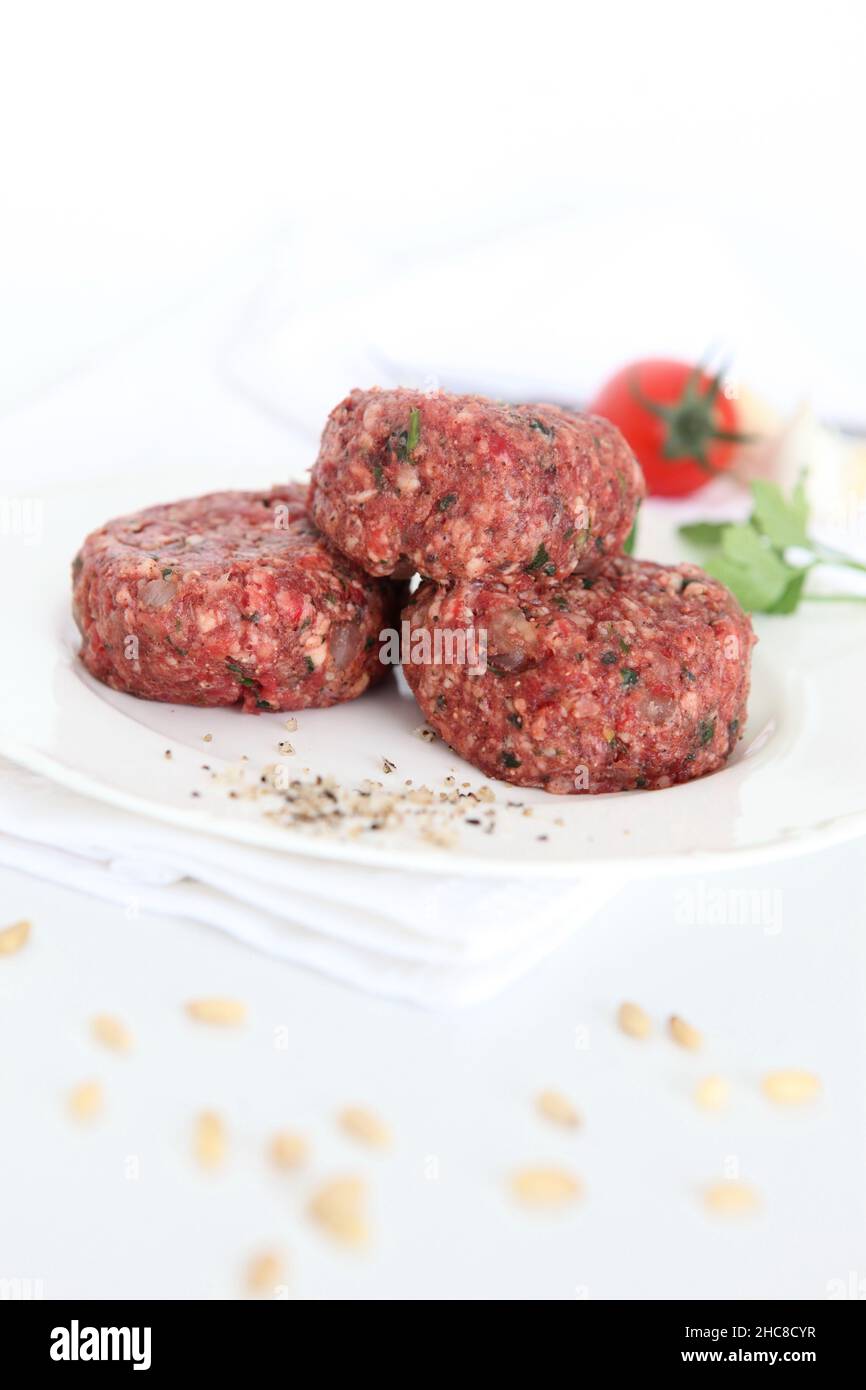 a stack of Raw spiced Kebab on wooden platter Stock Photo