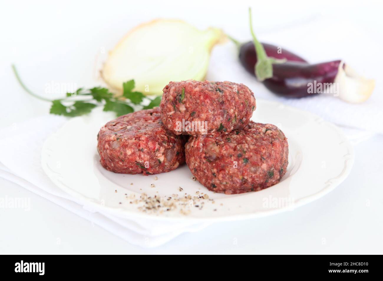 a stack of Raw spiced Kebab on wooden platter Stock Photo