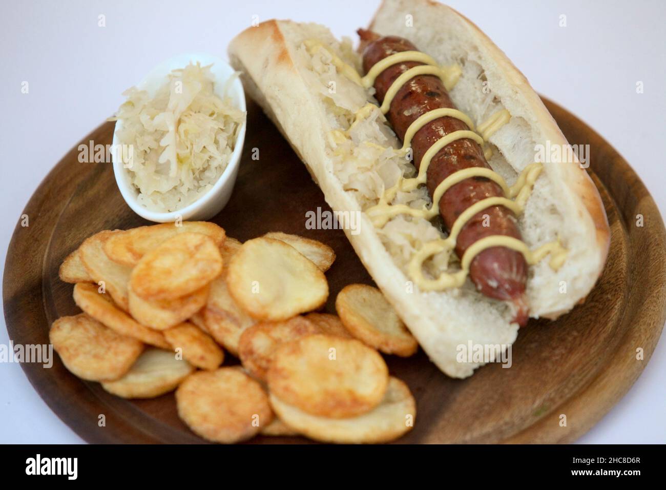 German Sausages (Bockwurst) hotdog with mustard roll and crisps Stock Photo