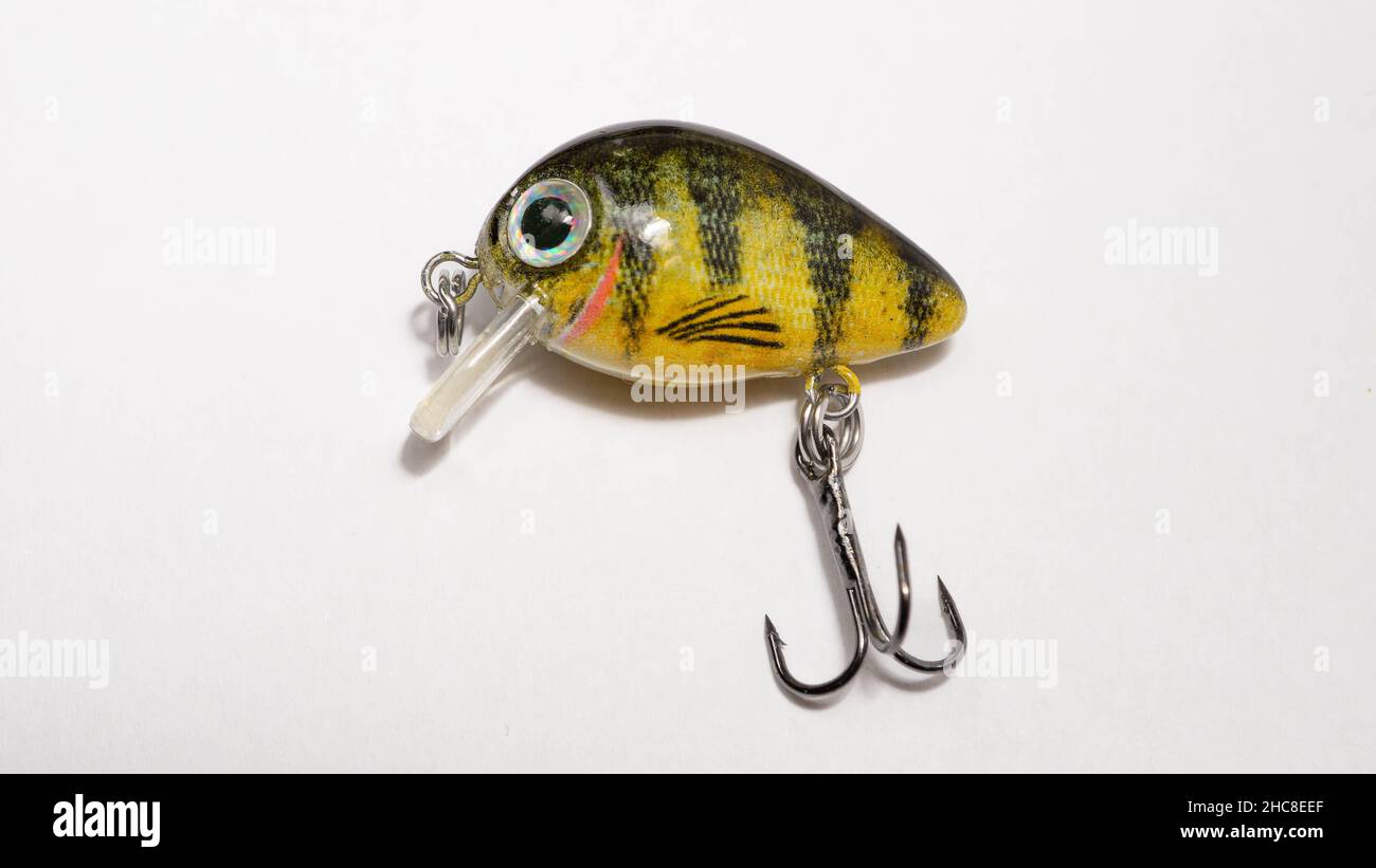 Closeup of bait for fishing in the shape of a yellow mini wobbler with a  hook on a white background Stock Photo - Alamy
