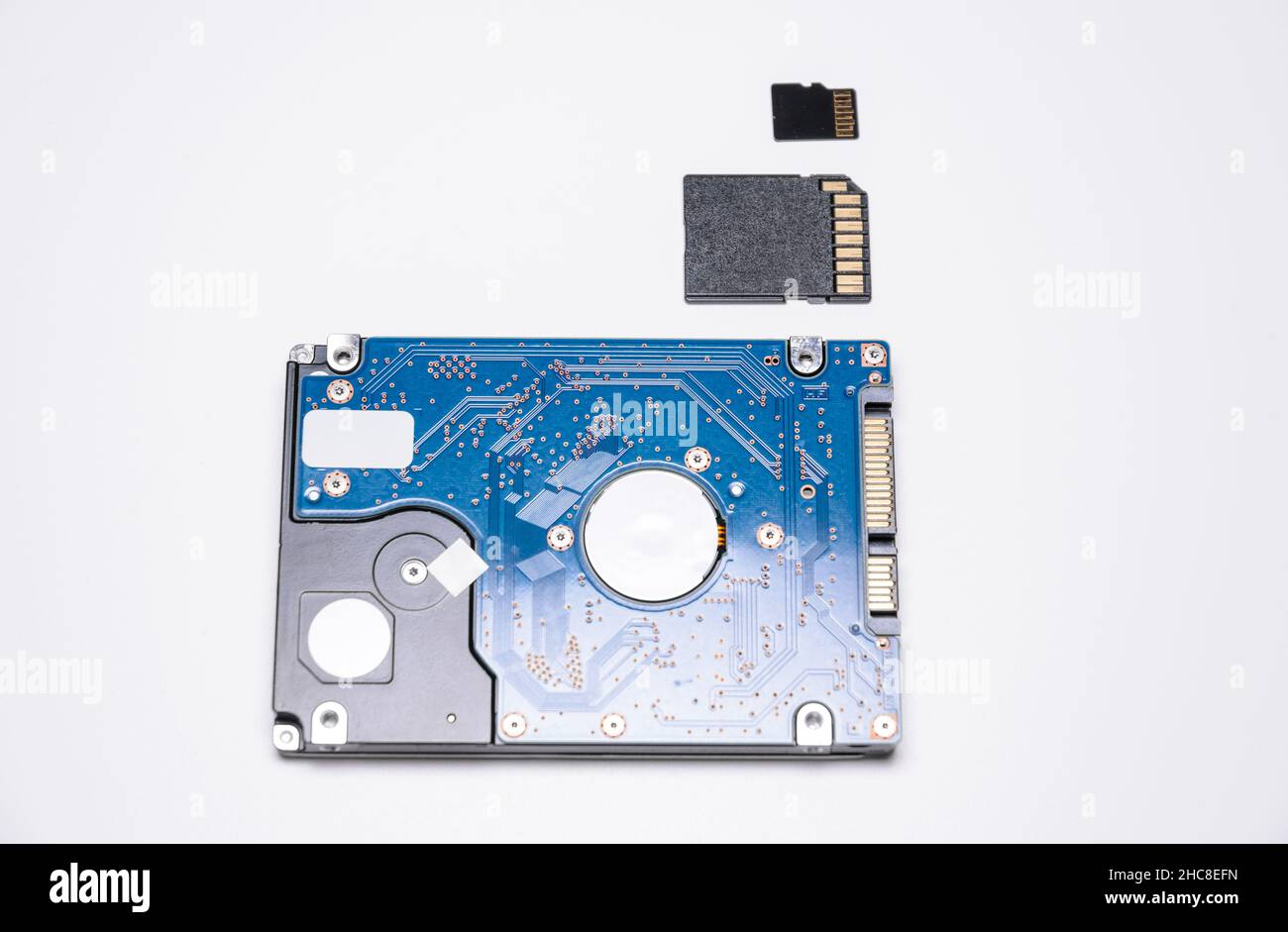 Internal 2.5 inch HDD Hard Disc Drive with SD Memory Card and micro SD card on white background, size comparison and differences of modern technology Stock Photo