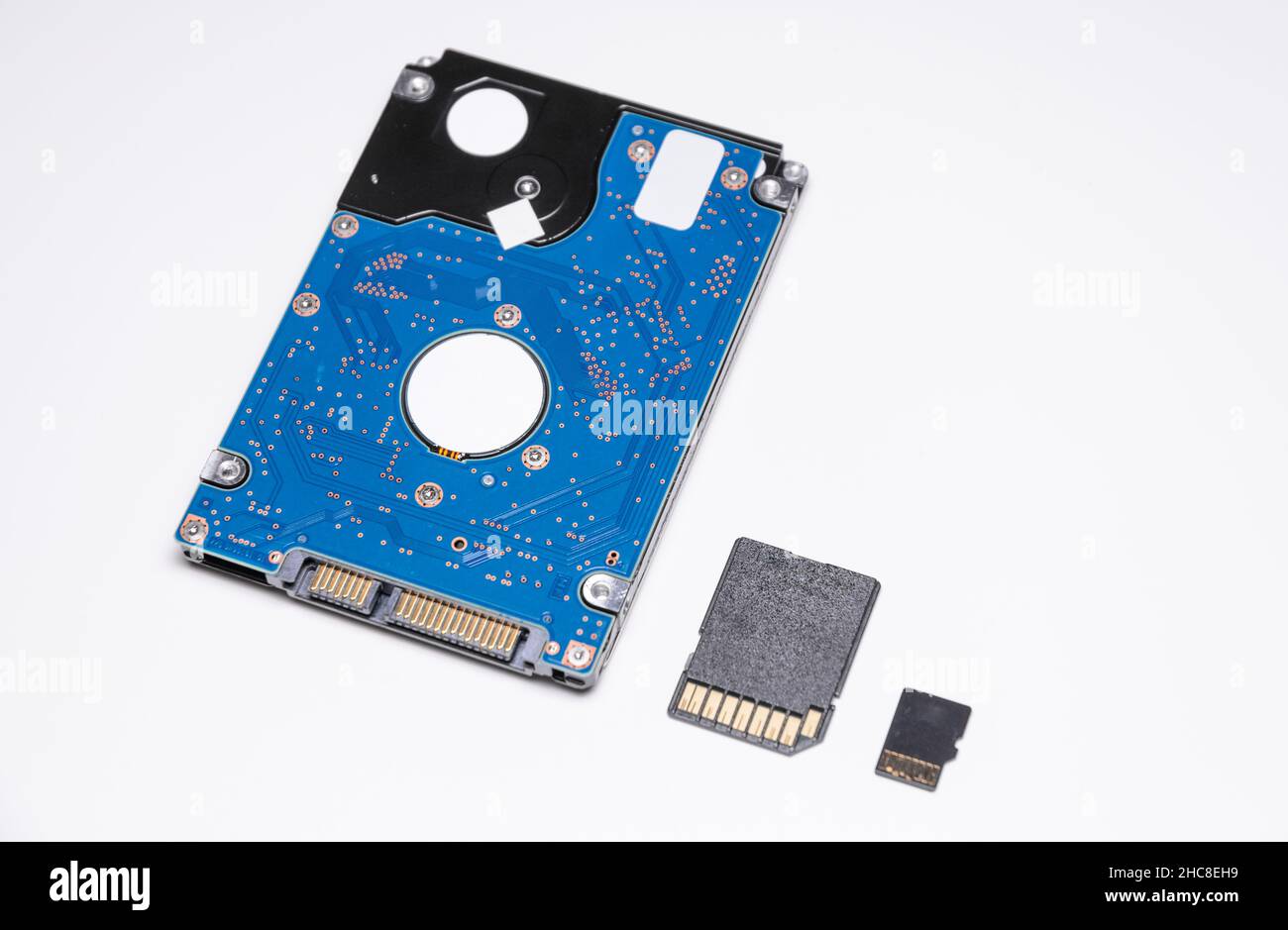 Internal 2.5 inch HDD Hard Disc Drive with SD Memory Card and micro SD card on white background, size comparison and differences of modern technology Stock Photo
