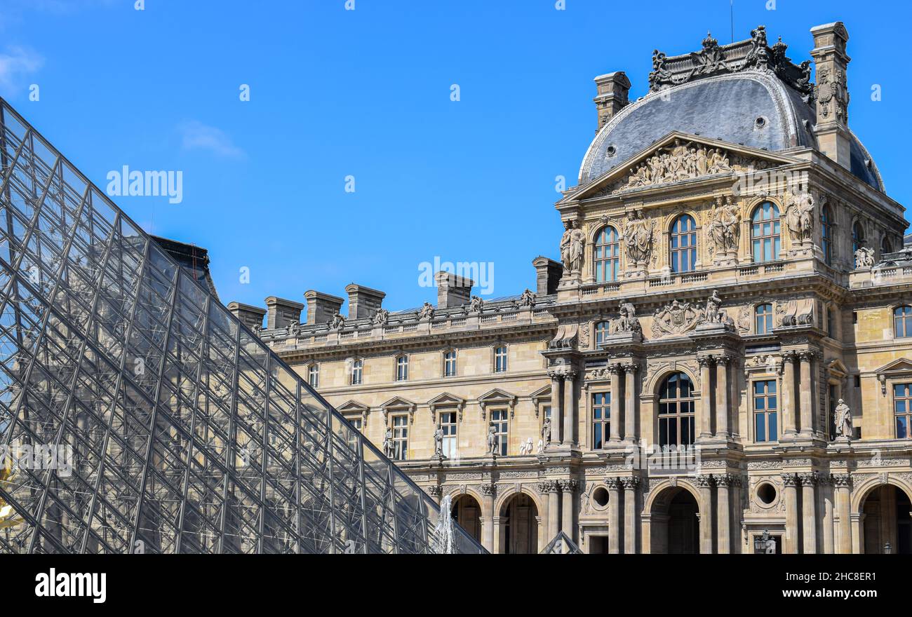 Fachada renacentista y estructura de cristal de la pirámide del museo Lovre en Paris, Francia Stock Photo