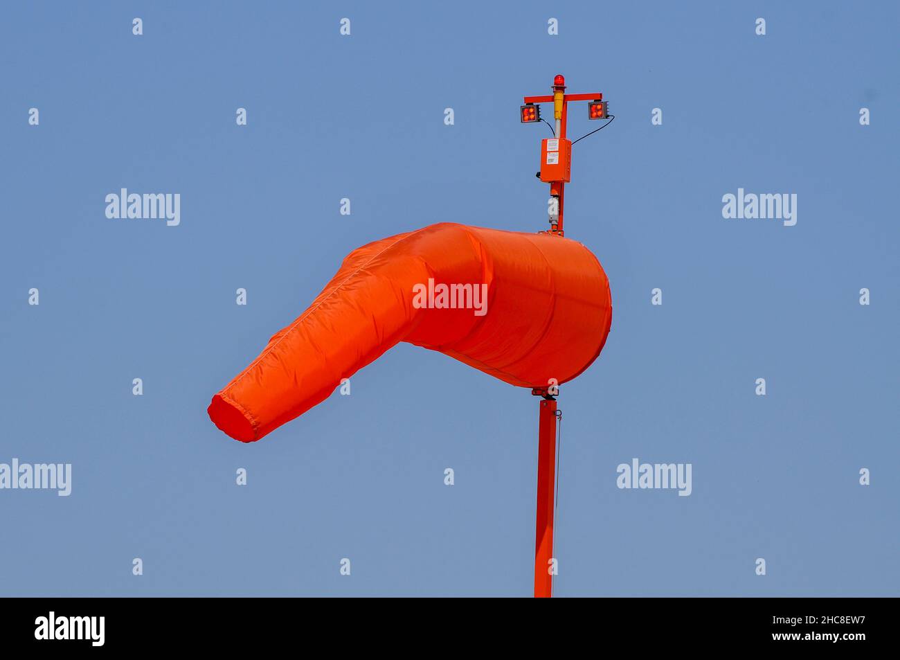 Orange Windsock on a blue sky background Photographed in an airfield in