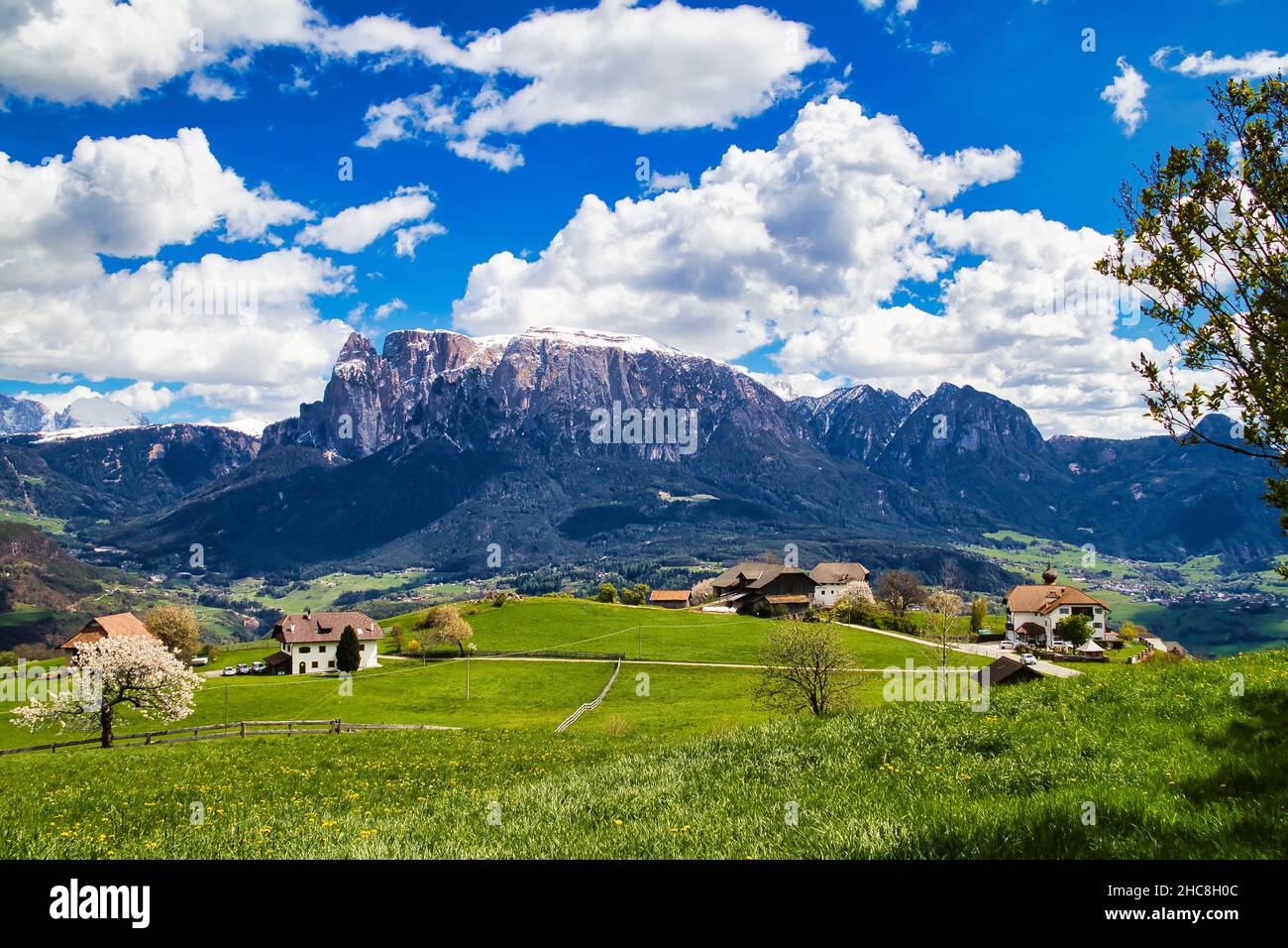 High angle of green fields with several tiny buildings with the ...