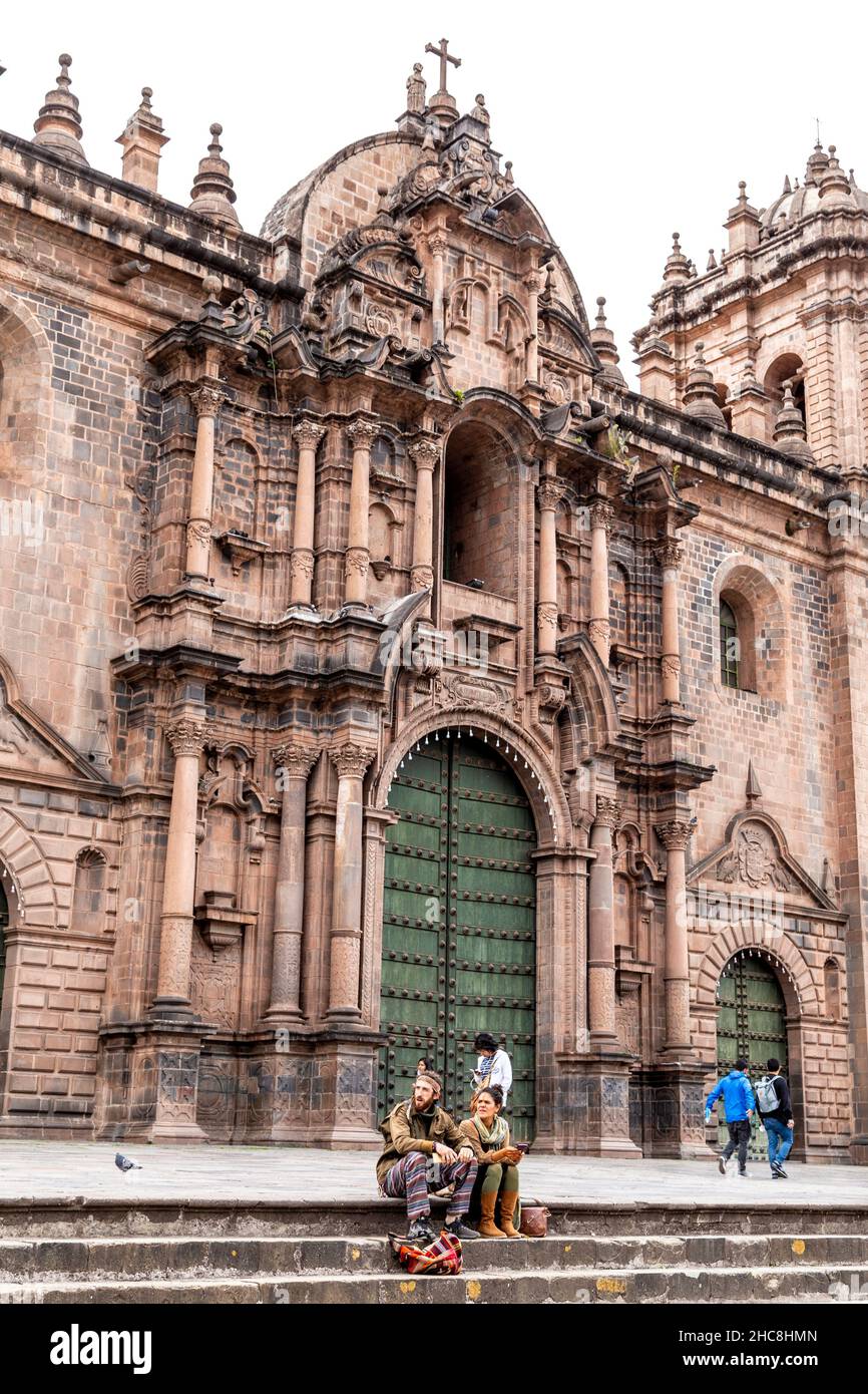 Hippie couple sitting outside Cusco Cathedral on Plaza de Armas, Cusco, Sacred Valley, Peru Stock Photo