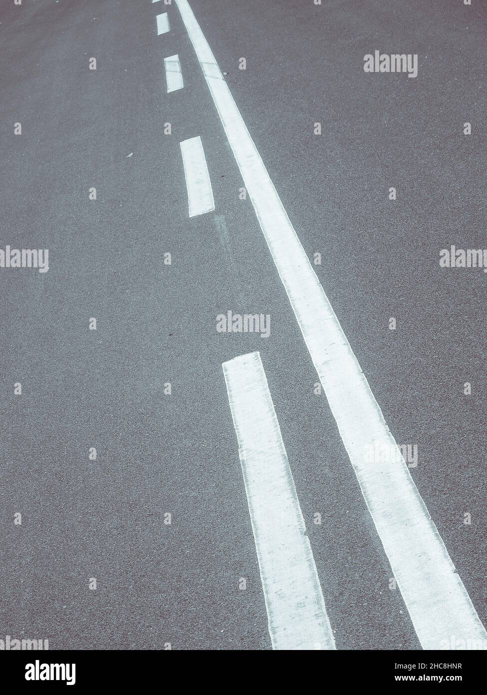 Vertical shot of a road with white line markings Stock Photo - Alamy