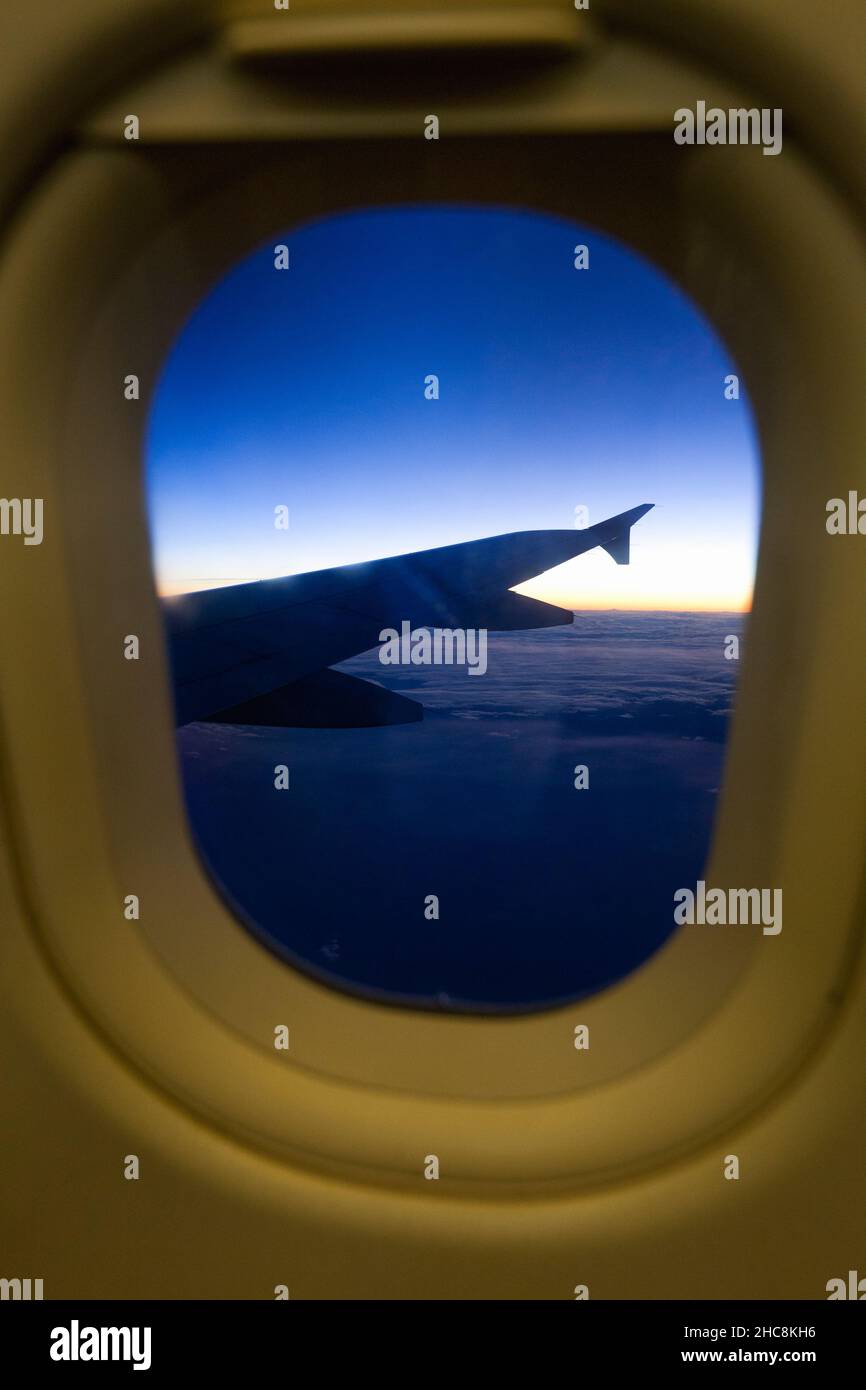 Airliner wing, viewed from passenger seat, through window. Stock Photo