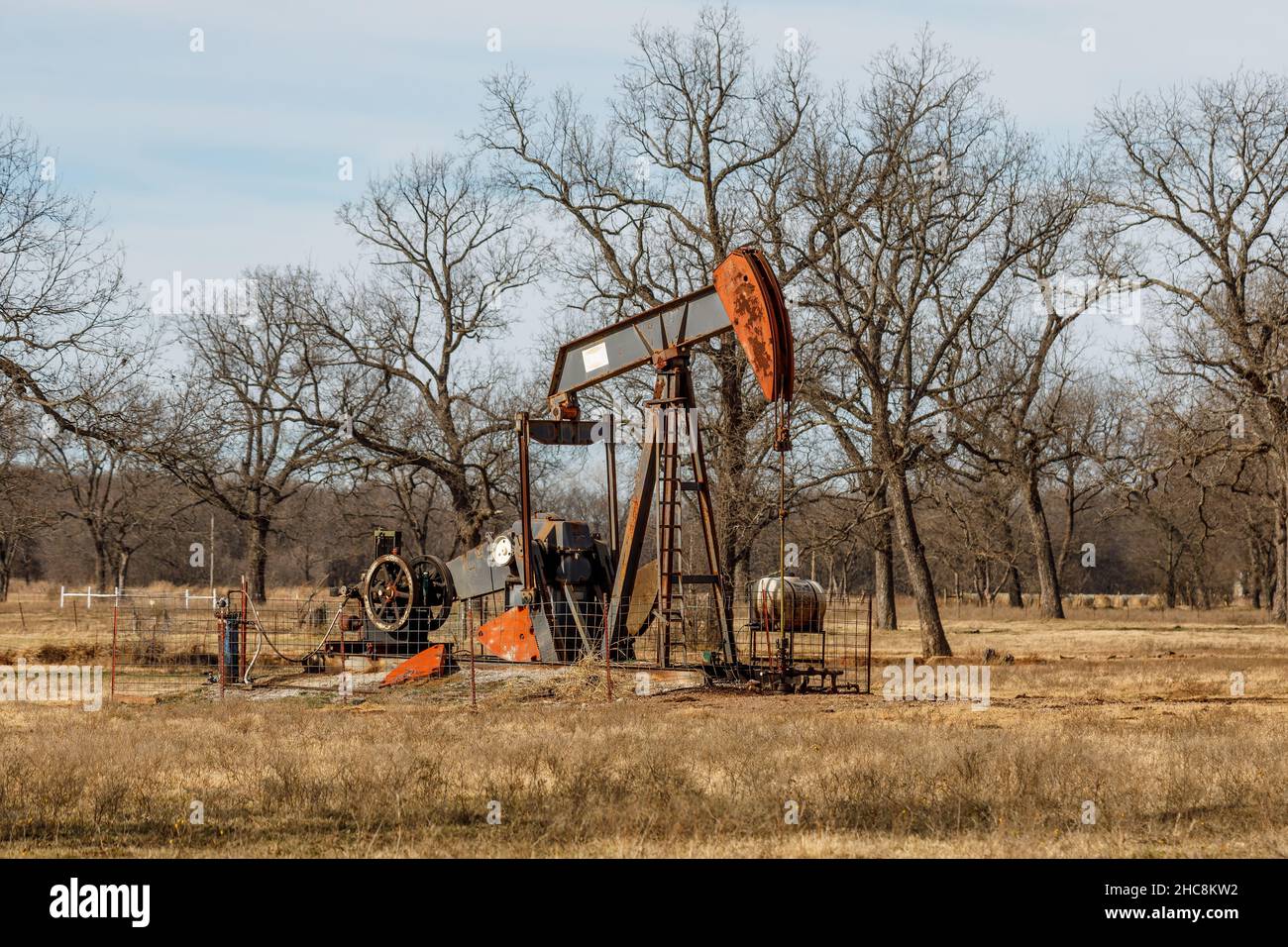 Old pump jack in a field. Stock Photo