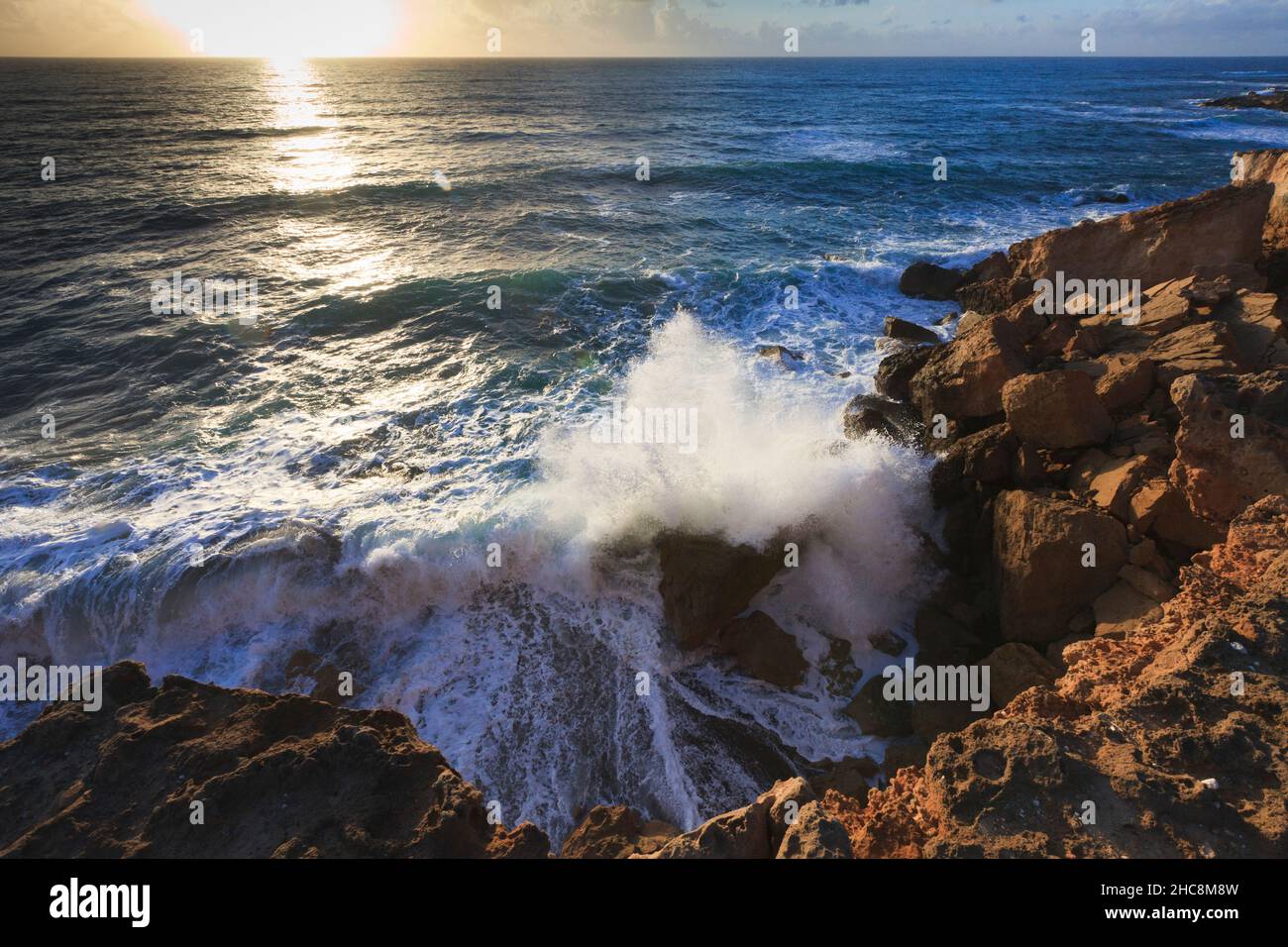 Sunset and waves crashing onto the rocky coastline in winter, Akamas peninsula, Island of Cyprus, eastern Mediterranean Stock Photo