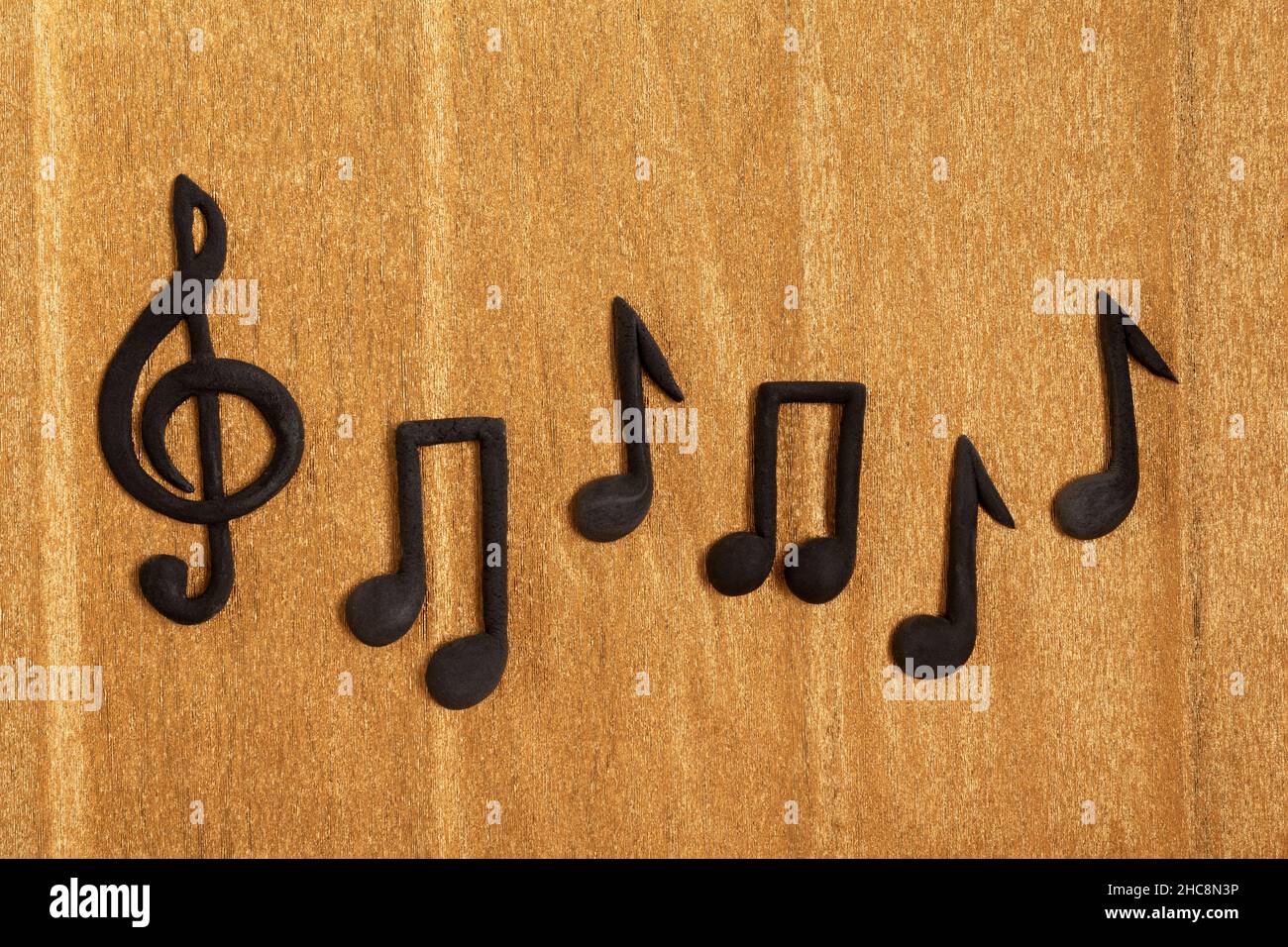 Black treble clef and music notes on golden background. Violin key. Key of G. Music symbol Stock