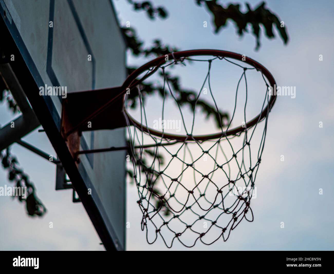 An old outdoor basketball hoop and net in school, In the evening when no one  plays Stock Photo - Alamy