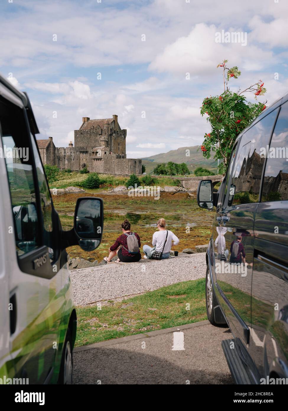 Visiting summer tourists relaxing on a summers day at Eilean Donan castle in Loch Duich, Kyle of Lochalsh, West Highlands Scotland UK Stock Photo
