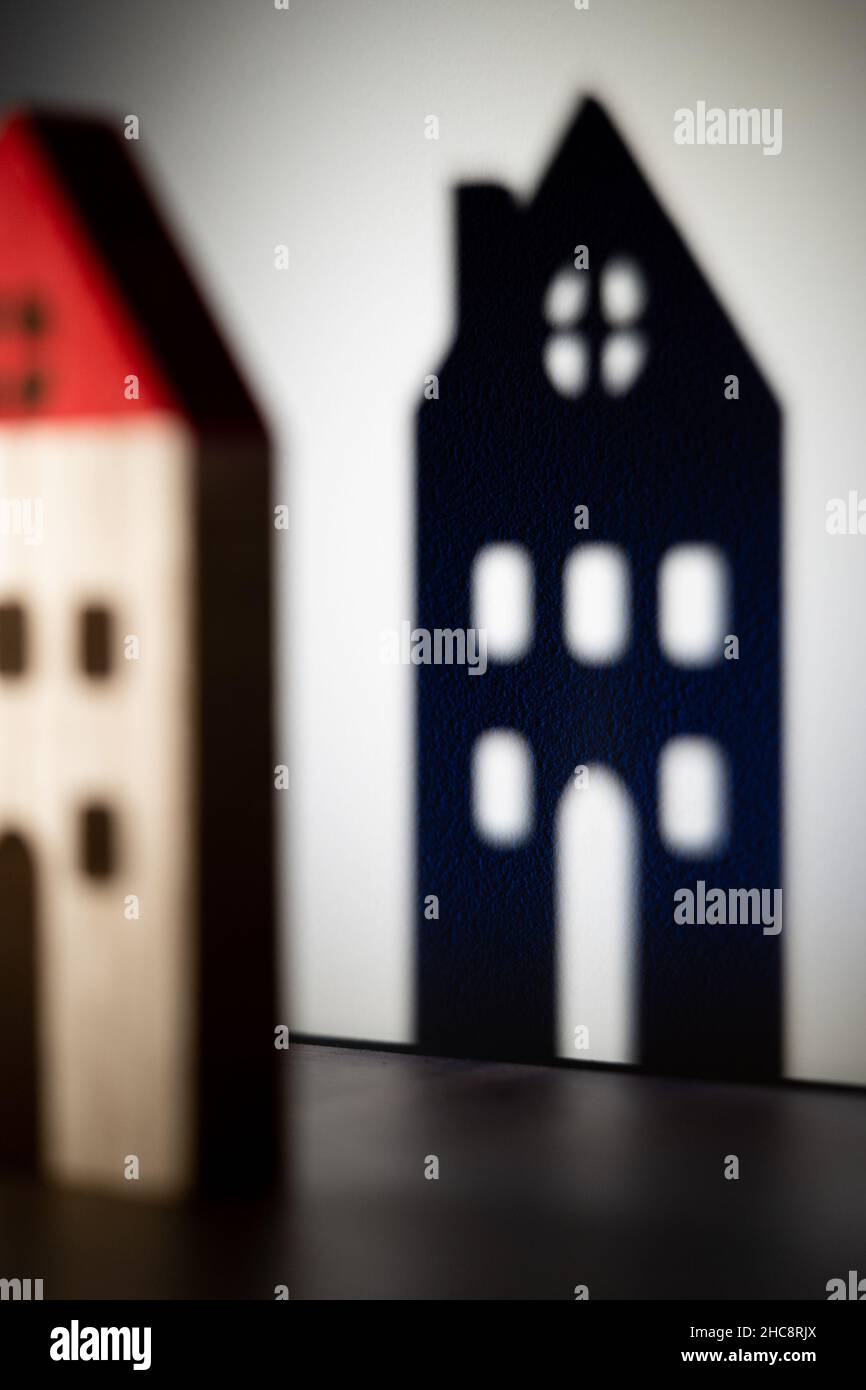 Toy house shadow on wall. Mortgage, residence insurance, real estate purchase. Shadow game for kids Stock Photo